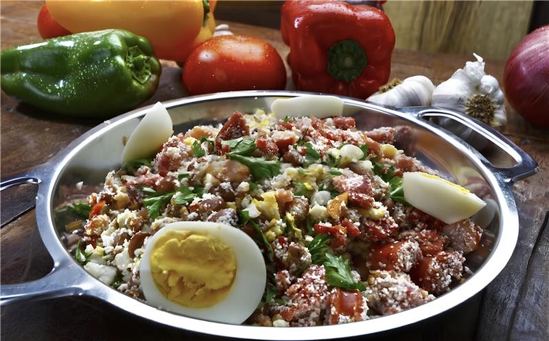 Feijão tropeiro com feijão vermelho servido em prato de barro, acompanhado de arroz branco, couve refogada e pedaços de torresmo crocante, típico da culinária brasileira.