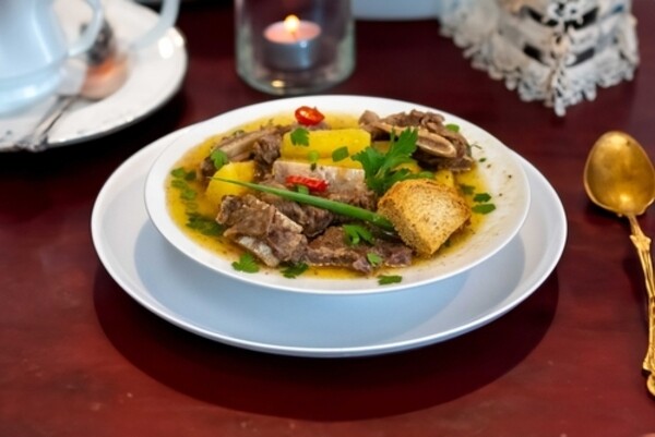 Vaca atolada com mandioca e costela bovina em prato fundo branco 