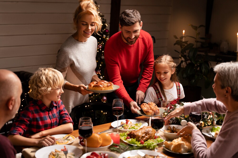 Família reunida ao redor da mesa celebrando um jantar festivo, com pratos variados e decoração acolhedora, representando união e momentos especiais em grupo.